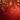 A vertical background image showcasing shimmering golden and red snowflakes hanging from the top against a soft-focus bokeh of golden lights. The backdrop features a rich, gradient red color, brightening at the top and darkening towards the bottom, with subtle golden light particles scattered throughout. This elegant holiday visual provides clear space below the decorations for text or design overlays.