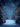 A vertical image depicts a magical, snow-covered street scene at night during winter. Tall, stately buildings adorned with holiday lights and warm glowing windows flank a central path, which is lined with numerous evergreen trees heavily decorated with colorful Christmas lights and covered in snow. Gentle snowflakes fall from the dark blue sky, creating a serene and enchanting festive atmosphere.