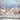 A festive vertical background image featuring a rustic, light-colored wooden plank surface in the foreground, with visible grain and texture. Above it, a dazzling display of blurred golden and soft blue circular bokeh lights glows softly, interspersed with numerous tiny, sparkling white glitter particles resembling falling snow. The overall impression is magical, elegant, and perfect for holiday or winter themes.