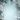 A vertical image featuring a frosted winter holiday frame surrounding a light blue background with falling snowflakes. The dense frame is composed of snow-dusted evergreen branches, several brown pine cones, and icy white leaves resembling holly and poinsettias, creating a intricate border around a clear central space. Delicate snowflakes of various sizes are scattered across the light blue gradient background, enhancing the serene and festive winter atmosphere.
