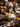 A close-up shot showcases a bowl of fluffy mashed potatoes, topped with a sprig of fresh herbs, sitting on a wooden table amidst a festive Thanksgiving spread. Miniature pumpkins, candles, and floral arrangements add to the warm, autumnal ambiance. The bowl has a white base with an intricate blue floral design along the rim.