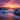 A vertical shot of a sunset scene with an ocean and rocky shore. The sky is filled with vibrant orange and purple clouds as the sun sets on the horizon. Waves are gently crashing against dark gray rocks, creating white foam, and the wet sand reflects the colors of the sky.