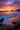 A breathtaking sunrise over a beach. The sky is a mix of orange and purple hues, illuminating the clouds. The waves are gently crashing onto the sandy beach, and dark rocks are visible in the foreground. The reflection of the sky paints the sand with a warm glow.
