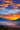 A vertical landscape photograph depicts a mountain valley at sunrise. Silhouetted mountain ranges recede into the distance beneath a vibrant sky filled with orange and yellow clouds. A thick blanket of fog fills the valley floor, obscuring the details of the landscape below, creating a mystical and dreamlike atmosphere.