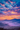 A vibrant landscape image shows mountain ranges at sunrise. The sky is filled with colorful clouds in shades of orange, pink, purple and blue. A thick mist fills the valley between the mountains, partially obscuring the ground and creating an ethereal effect.
