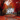 A white two-story house is centered in the image, surrounded by large trees with vibrant red and orange leaves. A pathway covered in fallen leaves leads up to the house. The scene evokes a sense of warmth and autumn serenity.