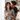 A smiling woman in a black and white striped shirt is holding a white mug while being hugged by a man from behind in a bright, modern kitchen. The man is kissing the woman's cheek, and both appear happy and content. The background includes white cabinets and a window with sheer curtains allowing natural light to flood the scene.