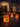 The image shows a nighttime scene of a stately home's walkway adorned with Halloween luminaries. Several paper bags with jack-o'-lantern faces are illuminated from within, casting a warm glow on the stone path. The scene is festive and inviting, perfect for celebrating the Halloween season.