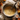 Overhead shot of baking scene. A silver mixing bowl filled with yellow batter sits on a countertop dusted with flour. Surrounding the bowl are various sized pumpkins, a wooden spoon with flour, a glass container of flour, and egg shells. Fall foliage in shades of red and orange is placed among the other ingredients.
