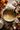 Overhead shot of baking scene. A silver mixing bowl filled with yellow batter sits on a countertop dusted with flour. Surrounding the bowl are various sized pumpkins, a wooden spoon with flour, a glass container of flour, and egg shells. Fall foliage in shades of red and orange is placed among the other ingredients.