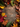 A top-down view of a rustic wooden surface framed by an abundance of colorful autumn foliage and natural elements. The border includes vibrant red, orange, yellow, and green leaves, bright red berries, various pinecones, and dark brown acorns, creating a warm, inviting seasonal frame around the central copy space.