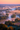 An aerial view of a winding river flowing through a misty valley at sunrise. Thick, soft fog blankets the lower landscape, with lush green and golden-orange trees emerging from the ethereal mist. The sky is a warm gradient of pink and orange, casting a magical glow over the tranquil and beautiful natural scene.