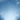 A serene vertical image of a winter scene with snow falling against a gradient blue sky. Bare tree branches, heavily coated in white snow and frost, frame the top and bottom edges of the image, creating a natural archway. The sky transitions from a darker blue at the top to a lighter, almost white blue at the bottom center, with numerous small white snowflakes gently descending across the entire frame.