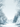 An illustrated vertical image of a serene winter scene. A snow-covered path leads through a forest, flanked by trees and bushes heavily laden with snow and ice. Bare branches and evergreen foliage are frosted white, and numerous white snowflakes are depicted actively falling against a soft light blue-grey sky, creating a peaceful and ethereal winter atmosphere.