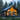 A sleek, dark gray modern house with an A-frame roof is positioned in a dense pine forest at dusk. Warm golden light emanates from its large, floor-to-ceiling windows, showcasing a minimalist interior and a comfortable outdoor lounge on a deck. The surrounding scene features tall green trees and lush ground cover under a soft blue-gray sky, conveying a tranquil and contemporary living space.