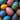 A top-down, close-up view of numerous brightly colored, hand-painted eggs. The eggs feature diverse patterns of dots, swirls, and intricate designs in vibrant hues like deep blue, teal, magenta, yellow, and purple, filling the entire frame. This image conveys a festive and artistic atmosphere, perfect for celebrating holidays or traditional craftsmanship.