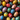 A top-down, full-frame view of dozens of brightly colored and intricately decorated Easter eggs. The eggs display a wide variety of patterns including polka dots, stripes, swirls, and floral designs, in a rich assortment of red, blue, yellow, teal, and white hues. They are tightly clustered together, creating a visually stimulating and festive appearance.