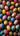 A top-down, full-frame view of dozens of brightly colored and intricately decorated Easter eggs. The eggs display a wide variety of patterns including polka dots, stripes, swirls, and floral designs, in a rich assortment of red, blue, yellow, teal, and white hues. They are tightly clustered together, creating a visually stimulating and festive appearance.