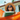 A young woman with a peaceful smile, wearing a straw hat and orange-framed sunglasses, reclines comfortably in a brightly colored orange hammock. She holds a green book in her hands, looking upwards as if enjoying the sunshine and a moment of quiet relaxation, with a blurred background of a house and blue sky.