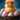 A fluffy yellow baby chick wearing bright pink-framed glasses sits prominently in a dark brown woven basket. It is surrounded by several speckled Easter eggs in soft pastel shades of pink, blue, and white, with orange accents. The background is a soft-focus, deep teal or blue fuzzy surface, creating a whimsical and adorable scene.