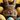 A very close-up, eye-level shot of a small brown bunny's face, looking directly at the viewer with dark, shiny eyes. The bunny is nestled within a dark, textured material, possibly a nest, which partially obscures its body. Around the bunny are several pastel Easter eggs: bright yellow ones with white polka dots and light blue ones with faint yellow-orange polka dots. The background is a vibrant, solid yellow, creating a bright and festive setting.