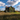 Professional overgrown abandoned house in autumn field under blue sky - high-quality image for marketing and content creation