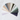 A flat lay photograph displays a fan of numerous color swatches arranged in a semi-circle across a white marble surface with faint grey veining. The swatches present a broad spectrum of muted colors, transitioning from light purples, whites, and creams to shades of beige, dusty blues, various greens, and dark purples, showcasing a cohesive and sophisticated color story.