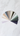 A flat lay photograph displays a fan of numerous color swatches arranged in a semi-circle across a white marble surface with faint grey veining. The swatches present a broad spectrum of muted colors, transitioning from light purples, whites, and creams to shades of beige, dusty blues, various greens, and dark purples, showcasing a cohesive and sophisticated color story.