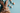 A fluffy brown and white Easter bunny peeks up from the bottom left of the frame, looking forward with its nose and one dark eye visible. It's set against a light teal background, which is adorned with several pastel speckled Easter eggs in peach, light blue, and off-white tones, along with a scattering of tiny colorful sprinkles. The composition is a flat lay, with the bunny taking up the lower portion and the eggs/sprinkles spread across the upper and right side of the image.